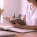 Woman journaling at a desk, reflecting on purpose and planning while faith fuels your momentum.