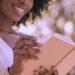 Woman reading and journaling in a notebook outdoors, reflecting and taking action as faith fuels your momentum.